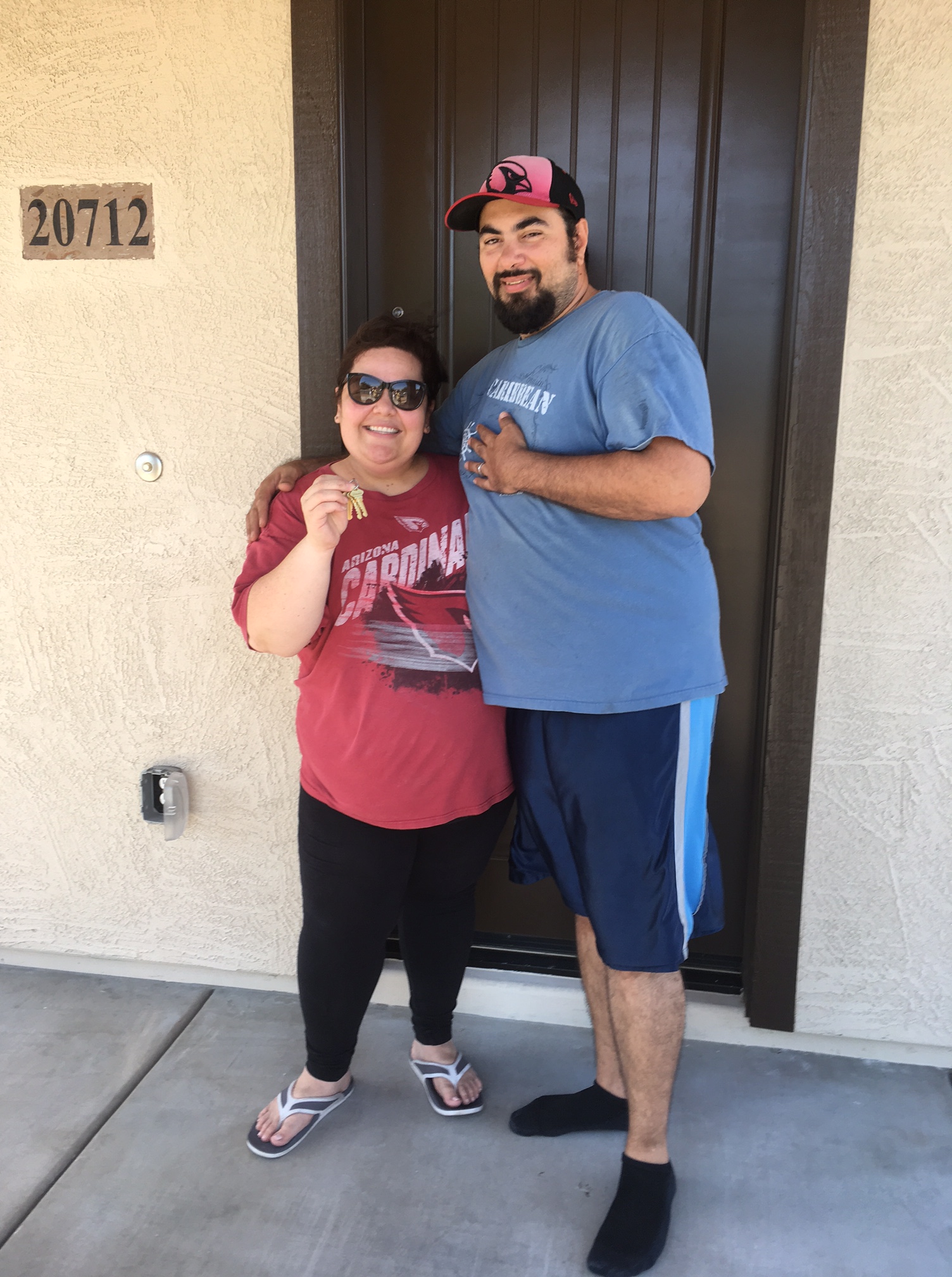 Couple holding keys by front door