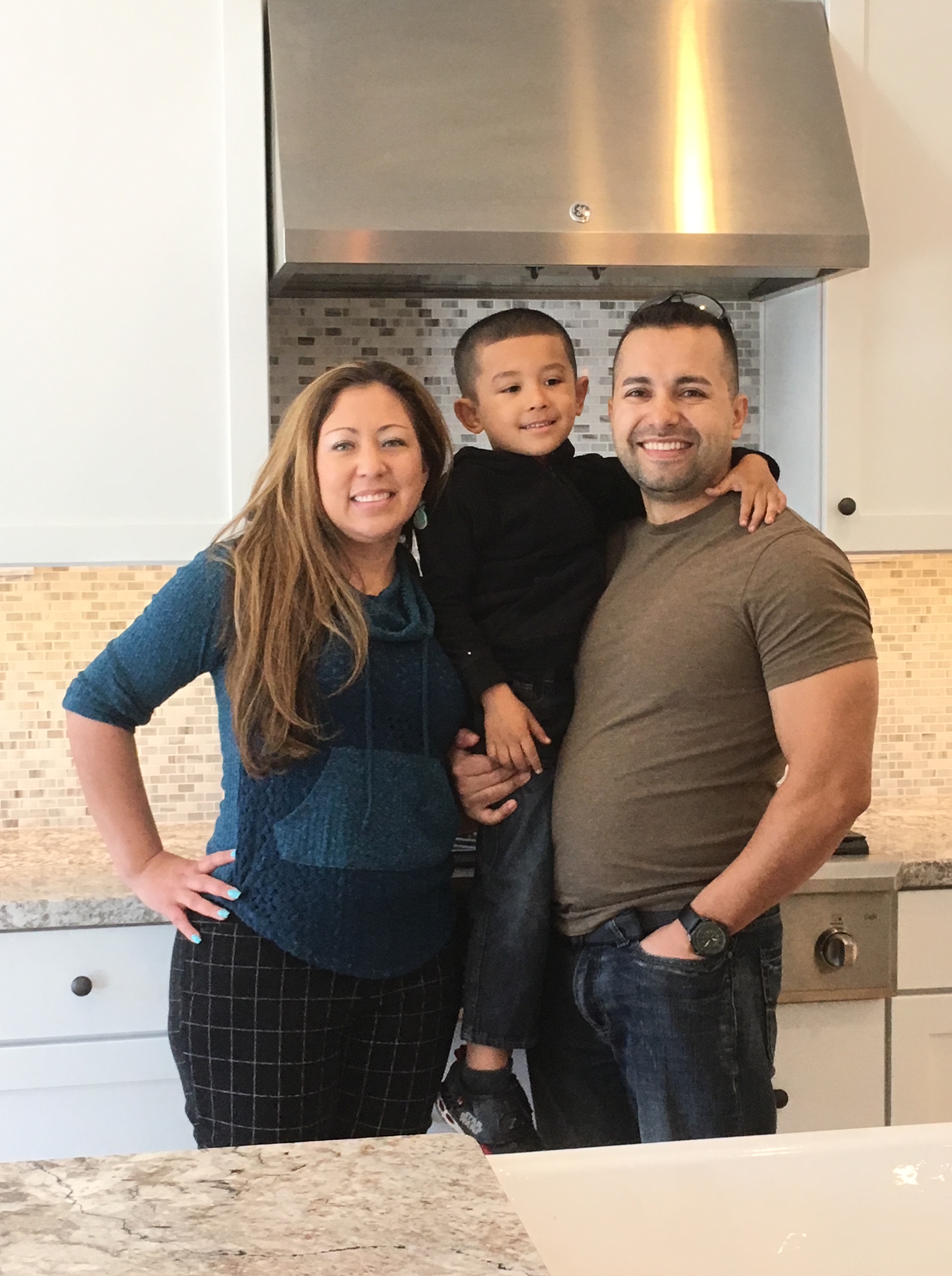 Smiling family of three in kitchen