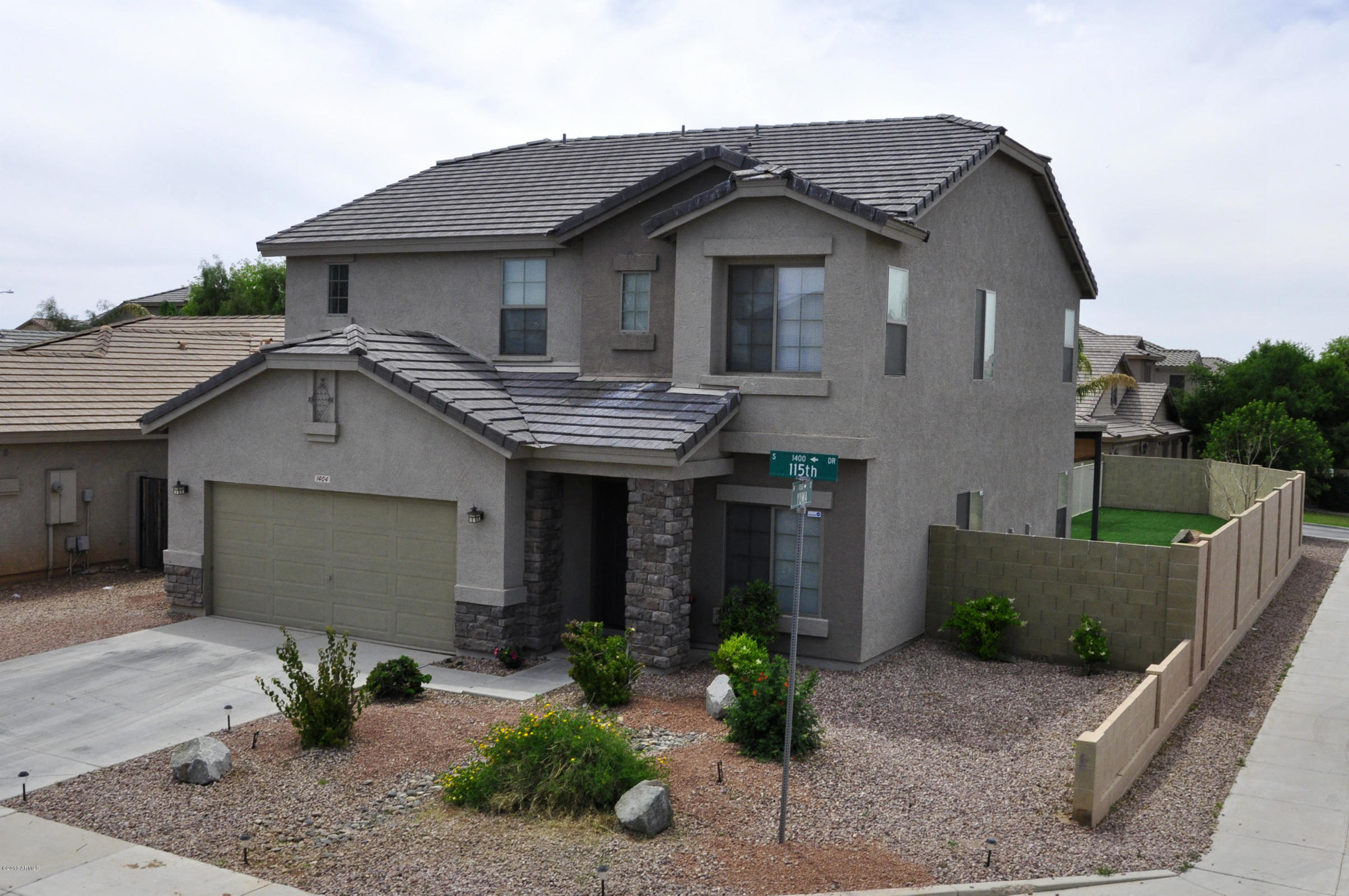 Two-story gray suburban house with desert landscaping