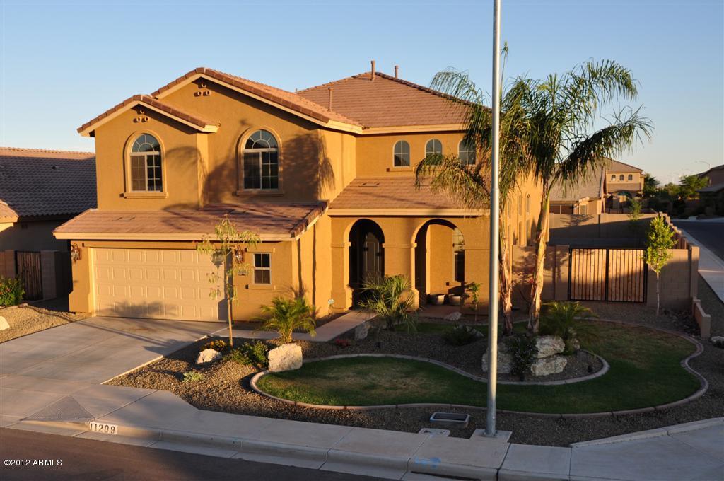 Two-story stucco suburban house with palm tree